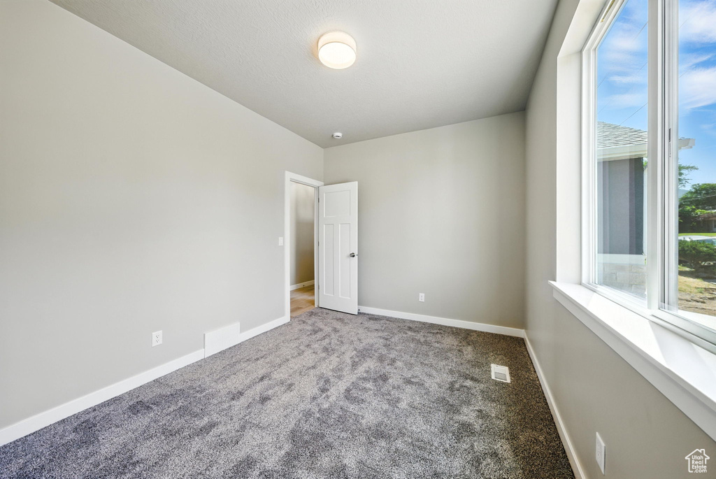 Empty room with carpet flooring and baseboards