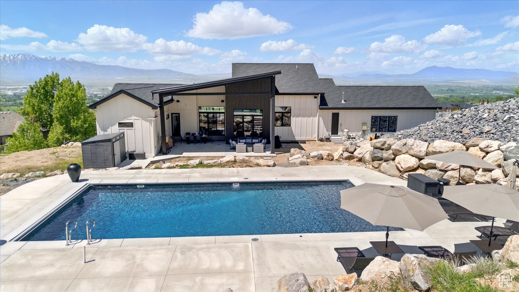 Outdoor pool with a mountain view and a patio