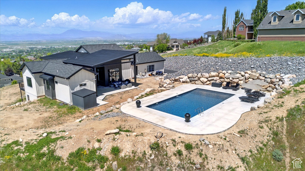 Swimming pool with a residential view, a patio, and a mountain view