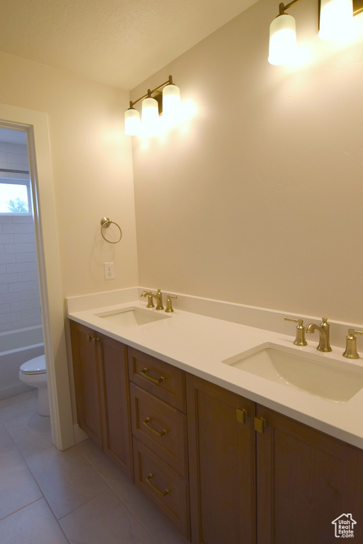 Bathroom featuring toilet, double vanity, and a tub