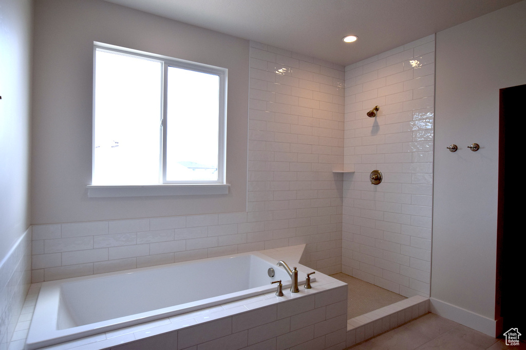 Bathroom with healthy amount of natural light, a tile shower, a bath, recessed lighting, and tile patterned flooring