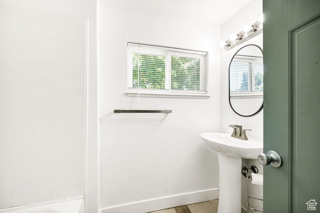 Bathroom with plenty of natural light, baseboards, and tile patterned flooring