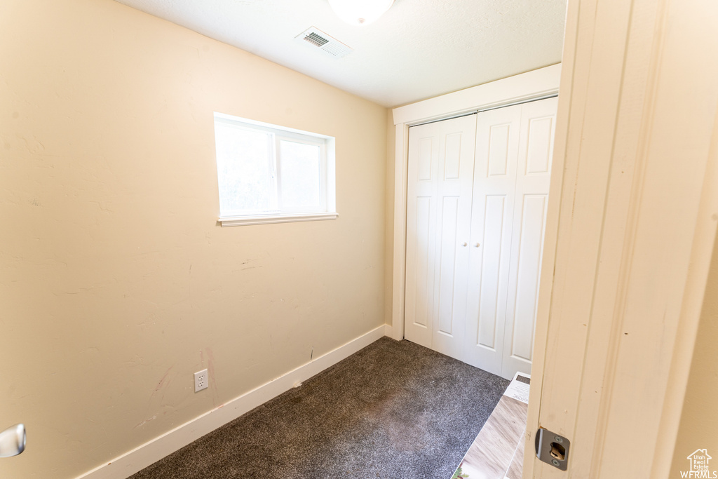 Unfurnished bedroom with baseboards, visible vents, a closet, and carpet