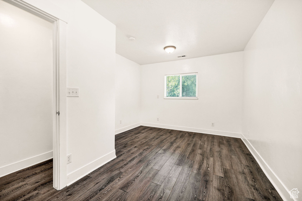 Unfurnished room with dark wood-style floors and baseboards