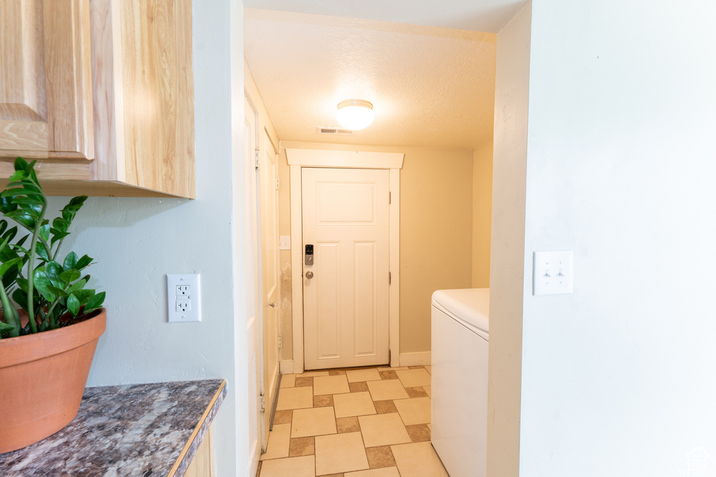 Washroom with visible vents, baseboards, washer / clothes dryer, laundry area, and light floors