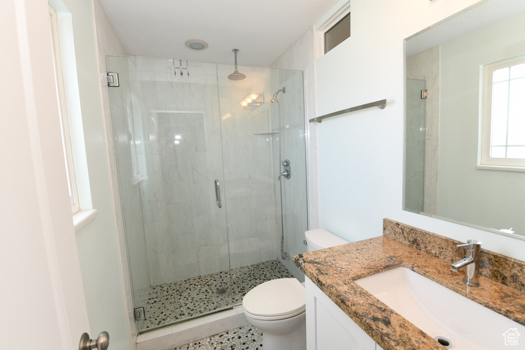 Full bathroom with toilet, a stall shower, and vanity