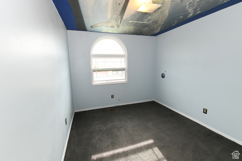 Carpeted empty room featuring baseboards