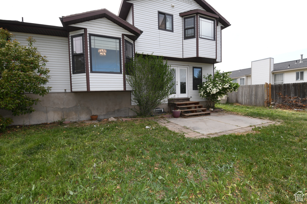 Back of property with entry steps, a patio, and french doors