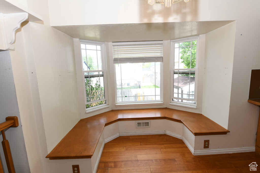 Unfurnished dining area featuring light wood-style floors, baseboards, and a chandelier