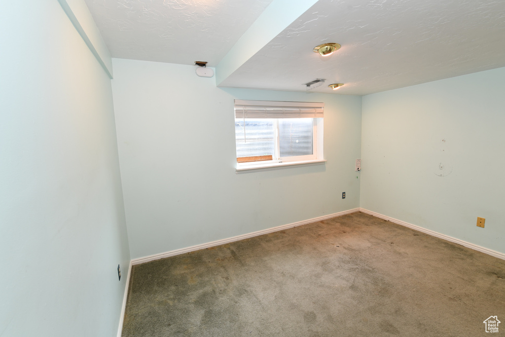 Empty room featuring carpet and baseboards