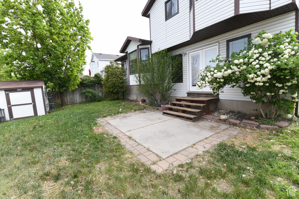 View of yard featuring entry steps, a shed, a patio area, and an outdoor structure