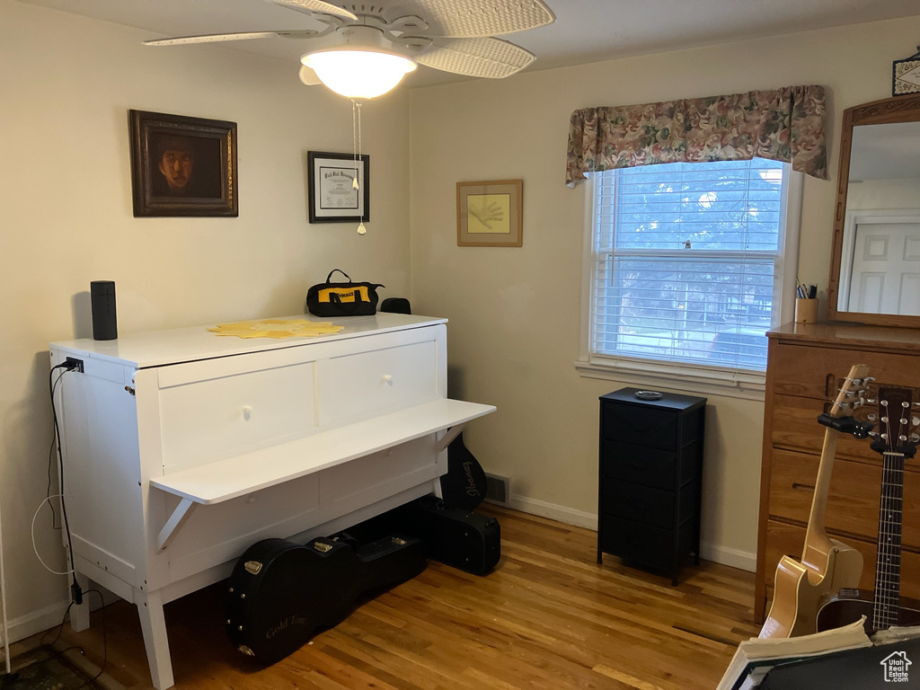 Misc room with baseboards, a ceiling fan, and wood finished floors