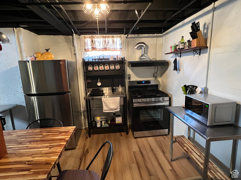 Kitchen with open shelves, stainless steel appliances, and wood finished floors