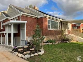 View of home's exterior featuring a lawn, brick siding, and a chimney