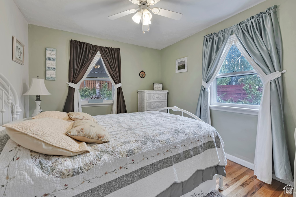Bedroom with wood finished floors, ceiling fan, and baseboards