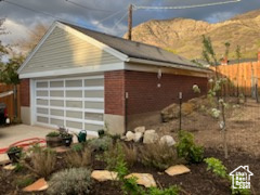 View of property exterior featuring fence, an outbuilding, and a mountain view