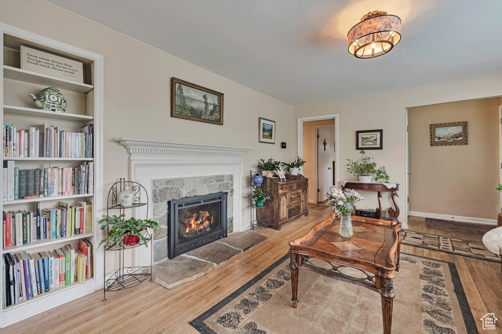 Living room with wood finished floors and a warm lit fireplace
