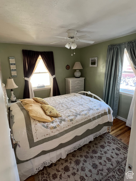 Bedroom featuring baseboards, a ceiling fan, and wood finished floors