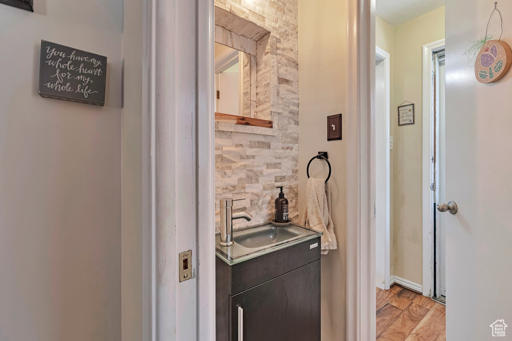 Bathroom featuring vanity, wood finished floors, and baseboards