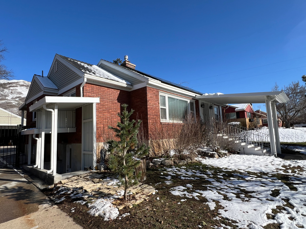 View of snow covered exterior with brick siding
