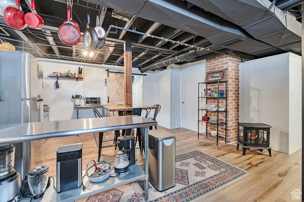 Finished below grade area with wood finished floors, a wood stove, and freestanding refrigerator