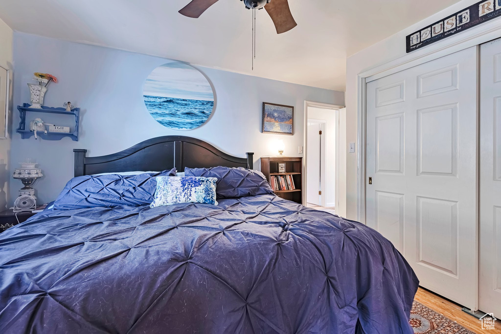 Bedroom with wood finished floors, ceiling fan, and a closet