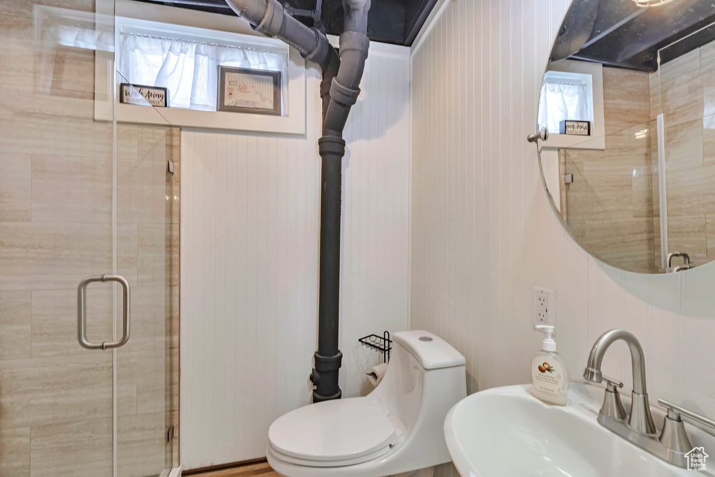 Bathroom featuring a sink, a shower stall, and toilet