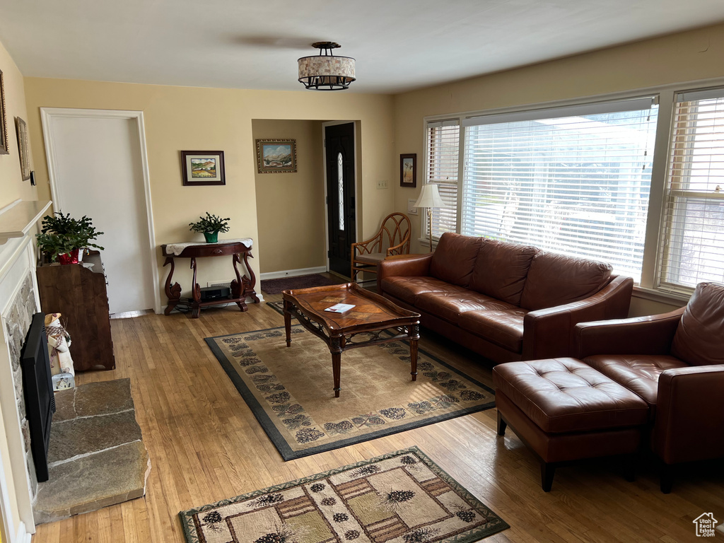 Living area with hardwood / wood-style floors, a tiled fireplace, and baseboards