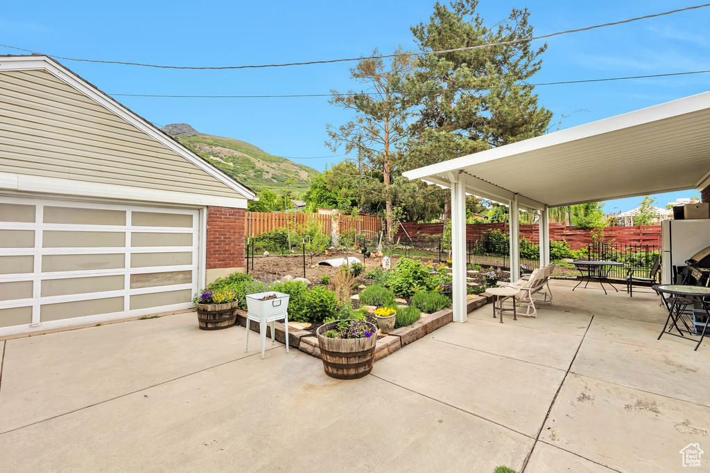 Fenced backyard with outdoor dining space, a patio, and a mountain view