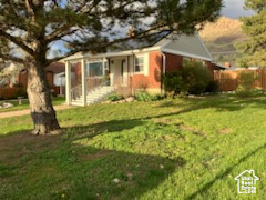 View of front of house with a front lawn and fence