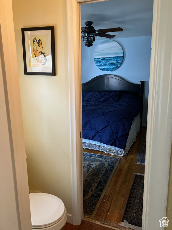 Bedroom featuring baseboards, wood finished floors, and a ceiling fan
