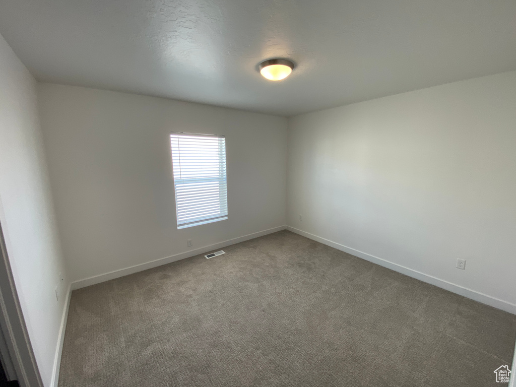 Unfurnished room with visible vents, carpet flooring, and baseboards