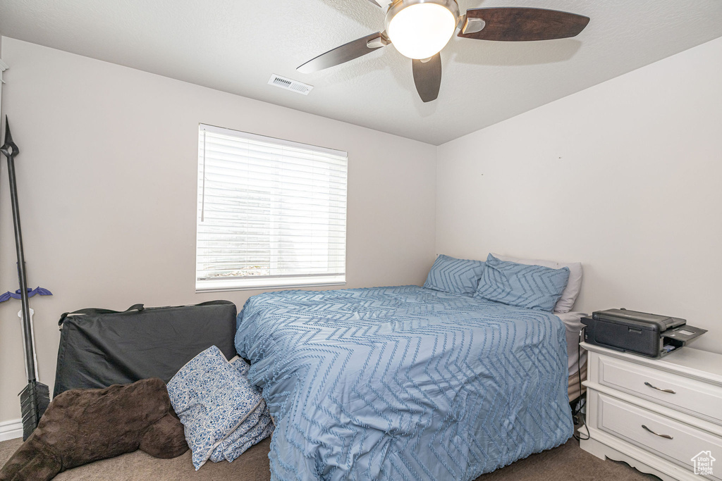 Carpeted bedroom featuring visible vents and a ceiling fan