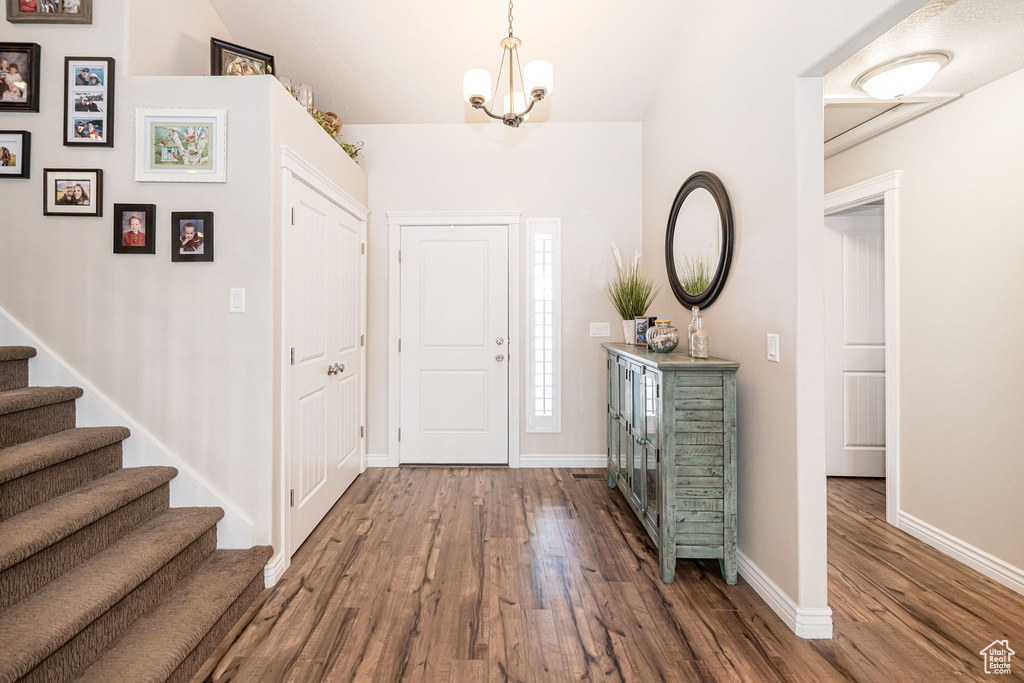 Entryway featuring stairs, wood finished floors, and baseboards