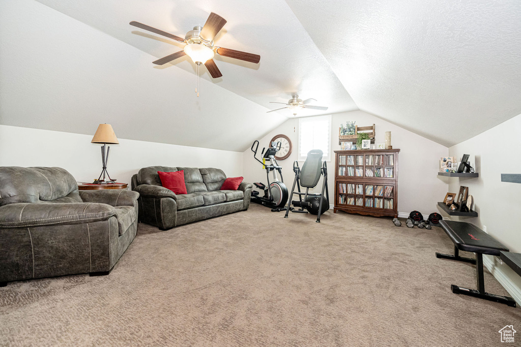 Living room featuring a textured ceiling, ceiling fan, carpet flooring, and vaulted ceiling