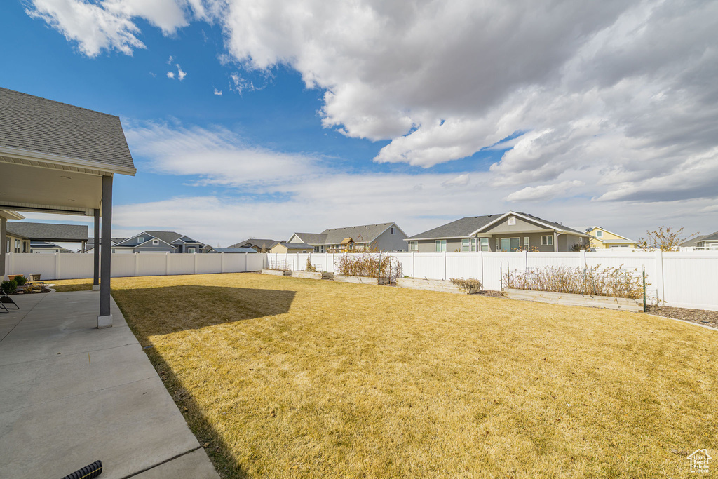 View of yard with a fenced backyard, a residential view, and a patio