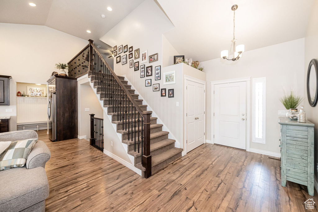 Foyer with stairway, wood finished floors, baseboards, recessed lighting, and a chandelier