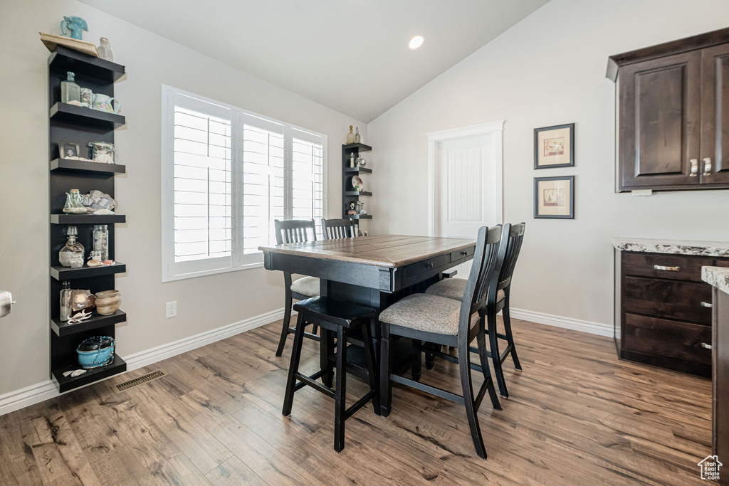 Dining space with visible vents, baseboards, vaulted ceiling, recessed lighting, and wood finished floors