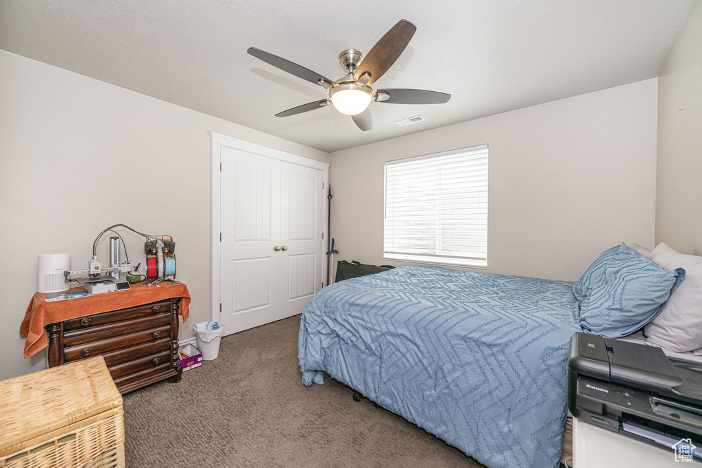 Bedroom featuring a closet, visible vents, a ceiling fan, and carpet