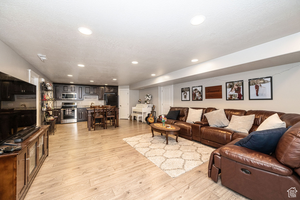 Living area featuring recessed lighting, light wood-style floors, and a textured ceiling