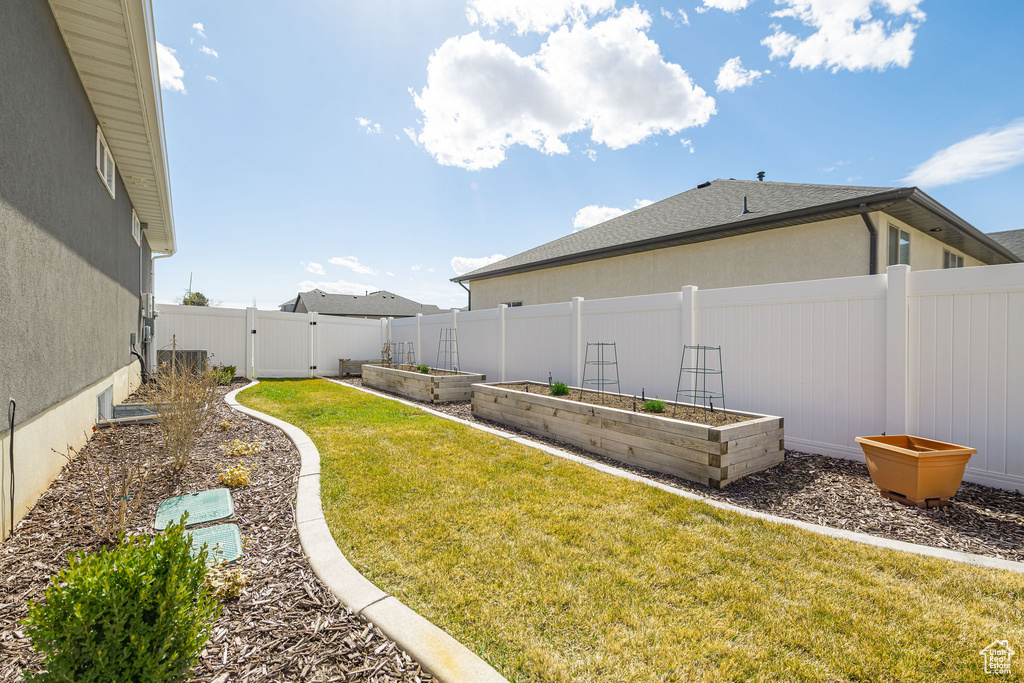 View of yard with a fenced backyard and a vegetable garden