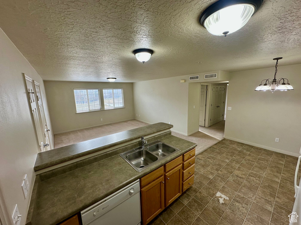 Kitchen with visible vents, a sink, open floor plan, brown cabinetry, and white dishwasher