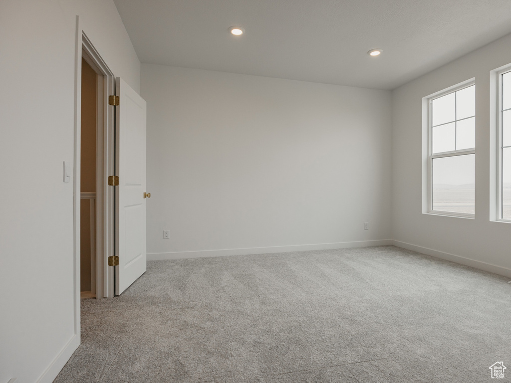 Unfurnished room with recessed lighting, visible vents, a healthy amount of sunlight, and carpet floors