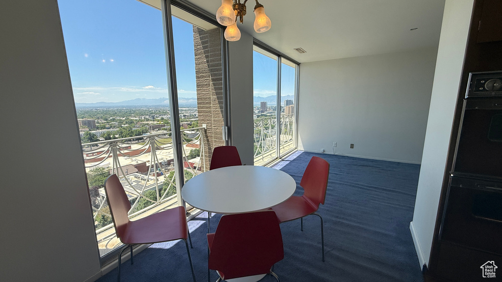Dining area with a city view, floor to ceiling windows, and baseboards