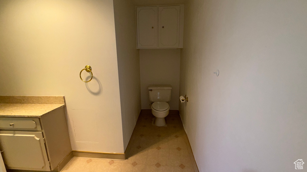 Bathroom with toilet, baseboards, and tile patterned floors