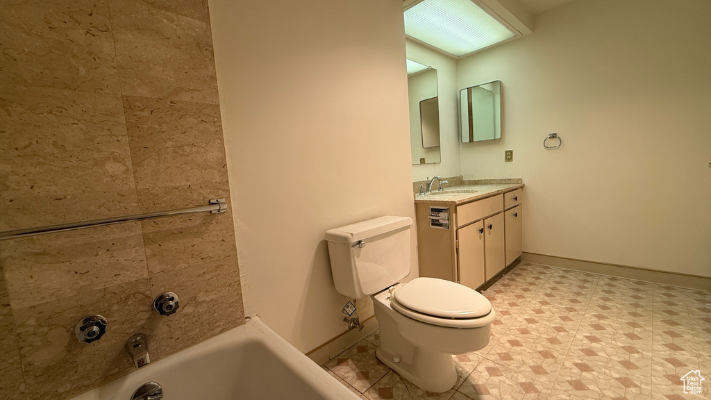 Full bathroom featuring vanity, toilet, and baseboards