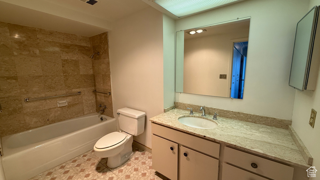 Bathroom with toilet, vanity, and  shower combination