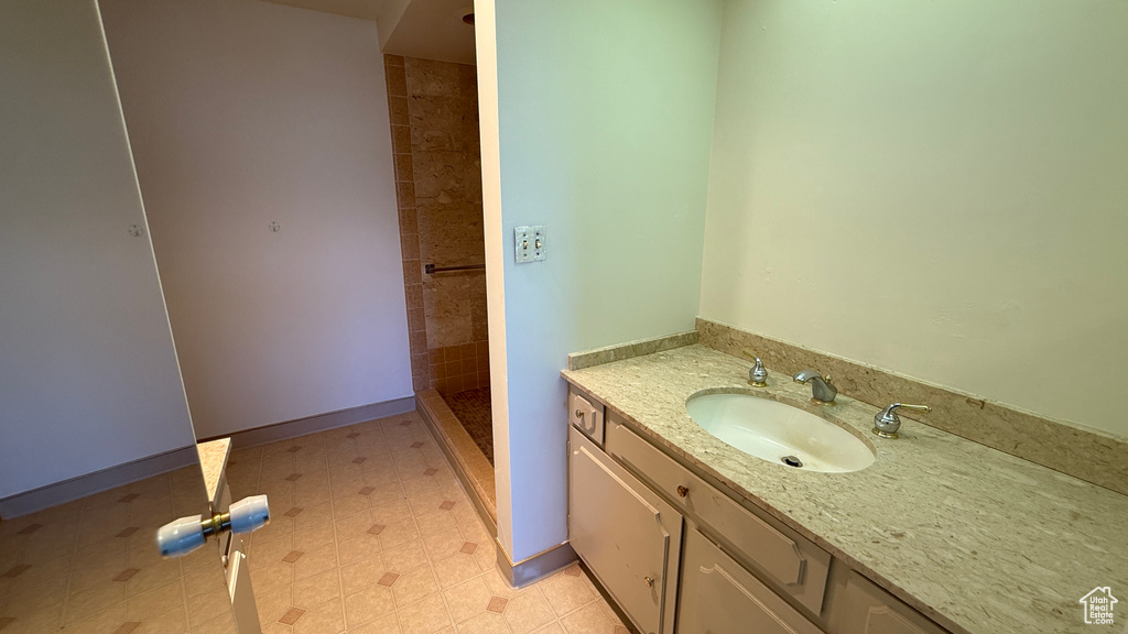 Full bath featuring vanity and a tile shower