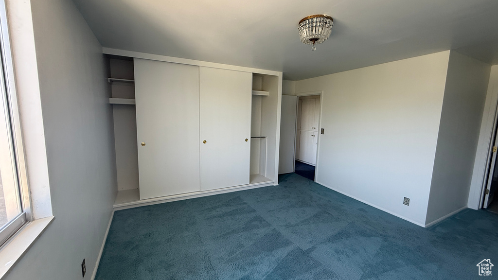 Unfurnished bedroom with carpet, a closet, and baseboards