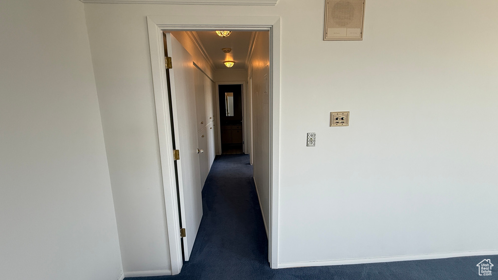Hallway featuring dark colored carpet